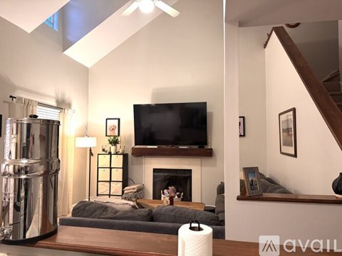 A living room with a grey couch and a fireplace.