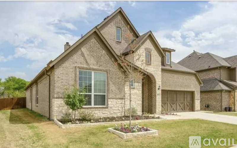 A house with a brown brick exterior and a large front yard.