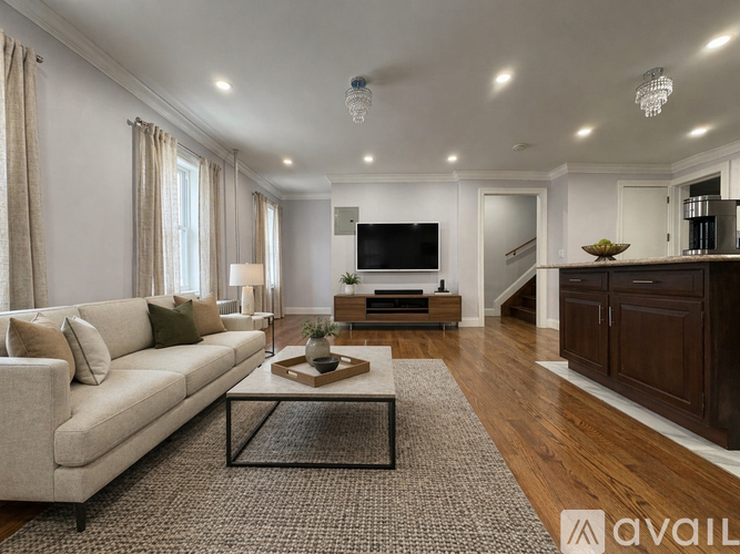 A living room with a beige couch, a coffee table, and a television.