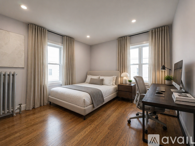 A bedroom with a large bed, desk, and chair.