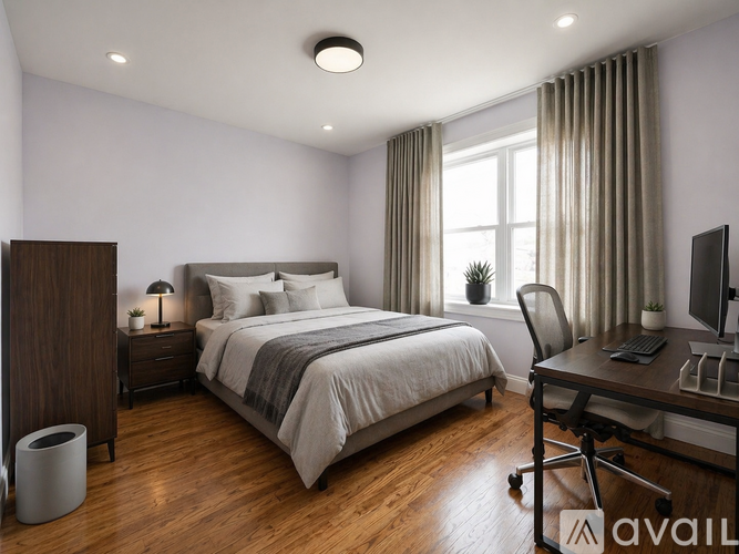 A bedroom with a bed, desk, and chair.