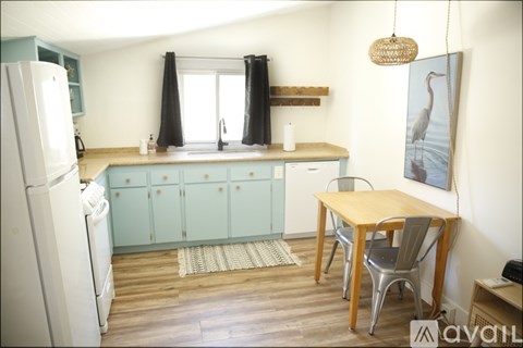 A kitchen with a table and chairs and a fridge.