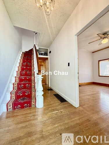 A living room with a staircase and a chandelier.
