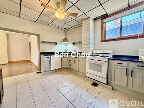 A kitchen with a tile floor and a ceiling fan.