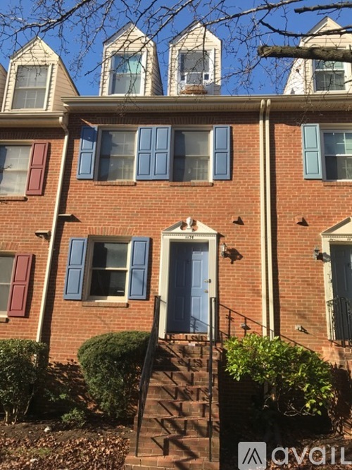 A brick house with a blue door and windows.