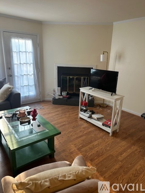 A living room with a green coffee table and a white TV stand.