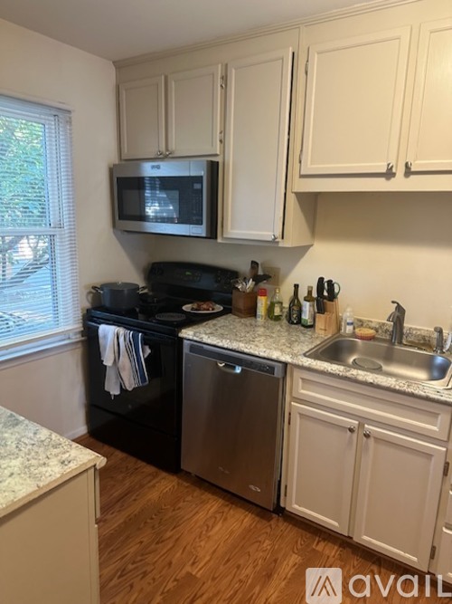 A kitchen with a black stove top oven and a microwave above it.