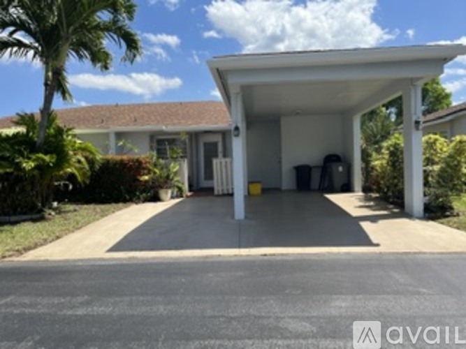 A house with a covered driveway and a garage.