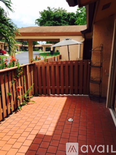 A patio with a wooden fence and a table with chairs.