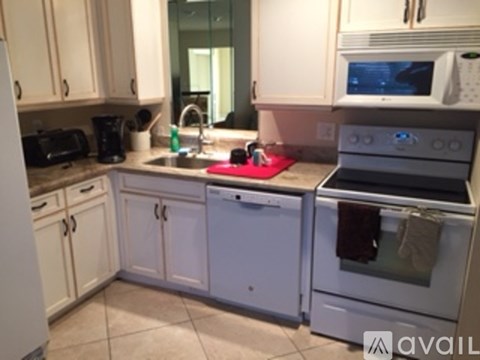 A kitchen with white cabinets and appliances.