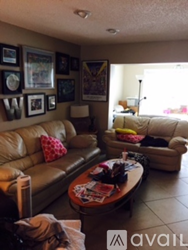 A living room with a couch, a coffee table, and pictures on the wall.