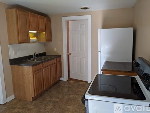 A kitchen with wooden cabinets and a white refrigerator.
