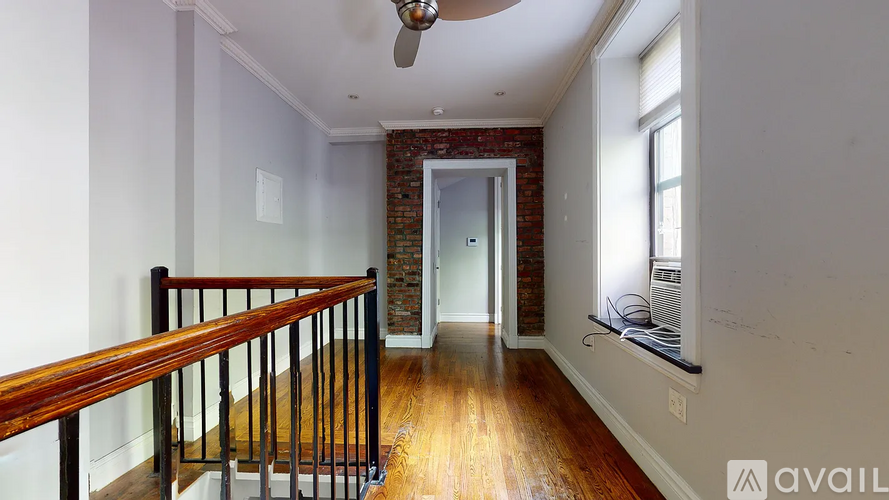 A room with a wooden floor and a ceiling fan.