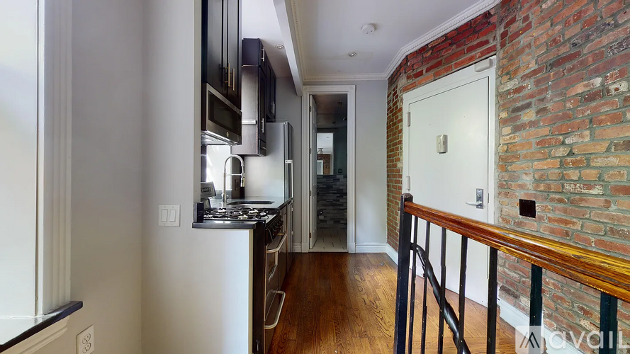 A kitchen with a brick wall and a white fridge.