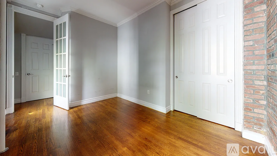 A room with wooden floors and white doors.