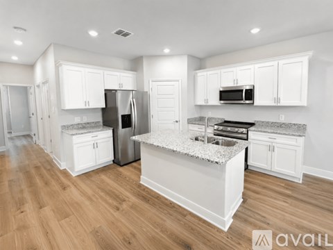 A kitchen with white cabinets and a granite countertop.