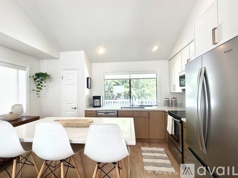 A modern kitchen with a dining table and chairs.