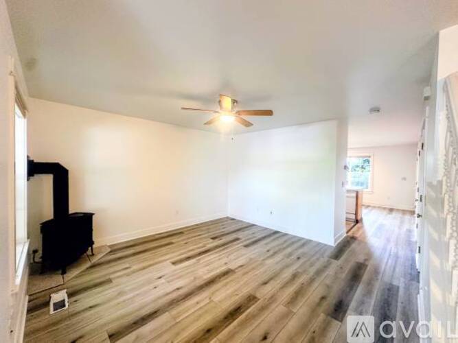 A room with a wood floor and a ceiling fan.