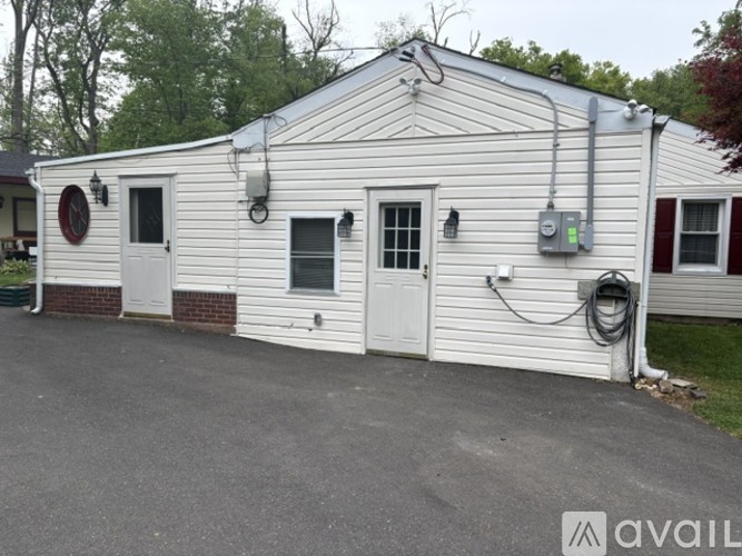 A white building with a red circle on the wall and a sign that says "available" in the bottom right corner.