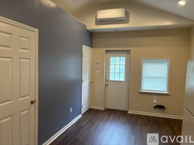 A room with a door, a window, and a wall with a window.