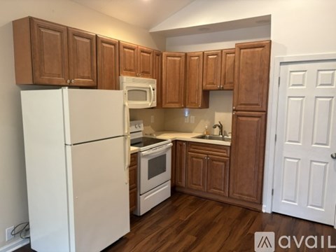 A kitchen with wooden cabinets and white appliances.