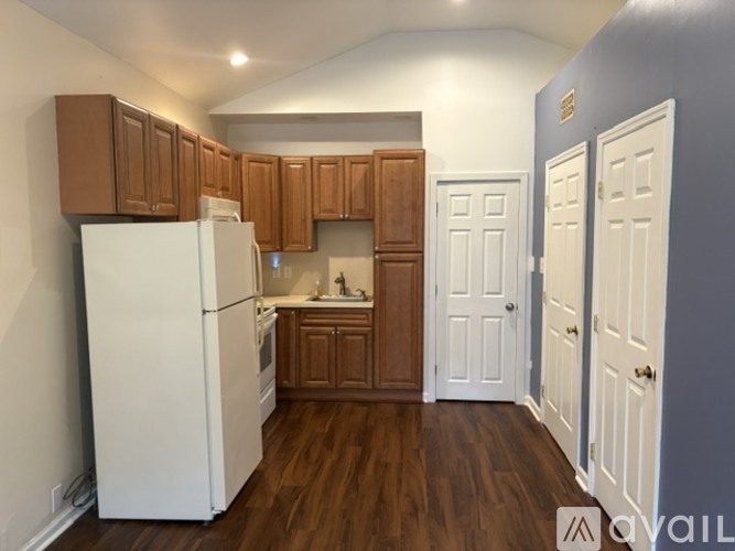 A kitchen with white appliances and wooden cabinets.