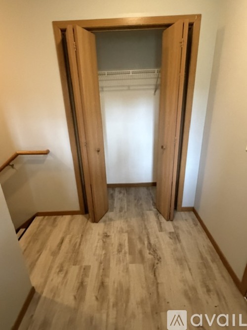A room with wooden floors and a door on the left.