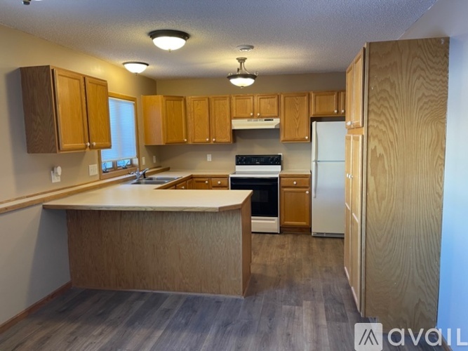 A kitchen with wooden cabinets and a white refrigerator.