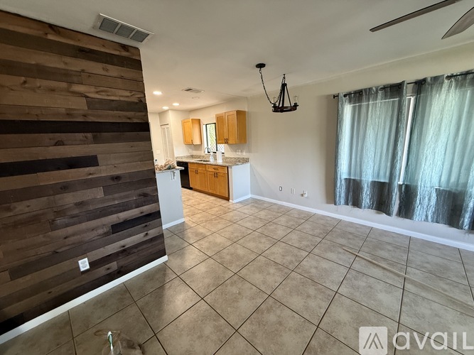 A kitchen area with a wooden wall panel and a tiled floor.