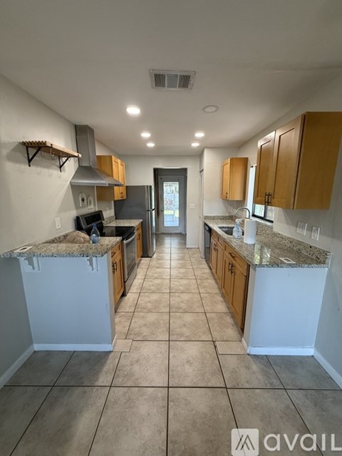 A kitchen with white and brown cabinets and a tiled floor.