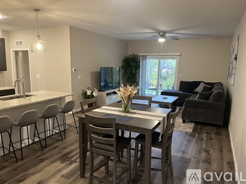 A dining room with a table set for six and a couch.