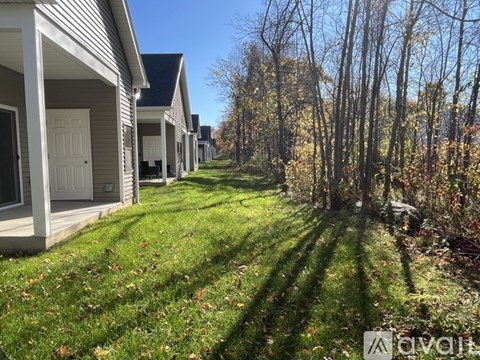 A row of houses with trees in front.