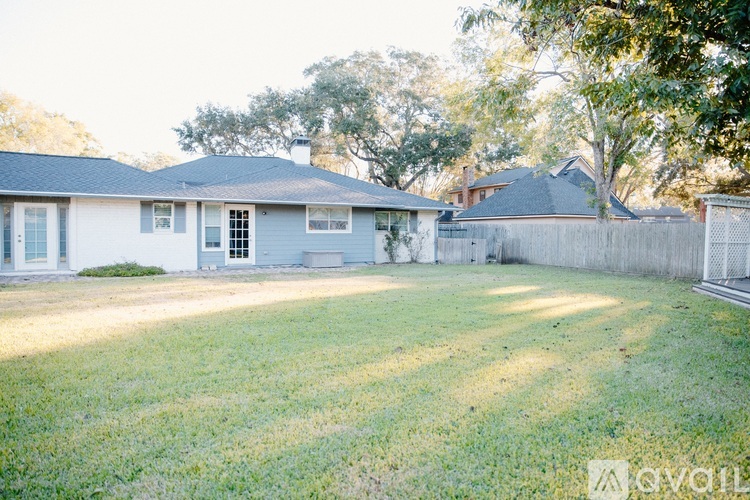 A house with a fence and trees in the background.