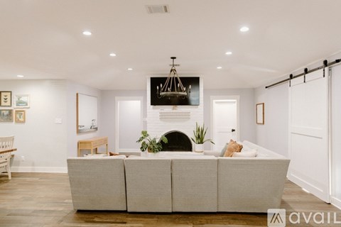 A modern living room with a white couch and a fireplace.