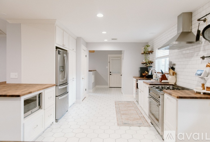 A modern kitchen with white cabinets and a wooden countertop.