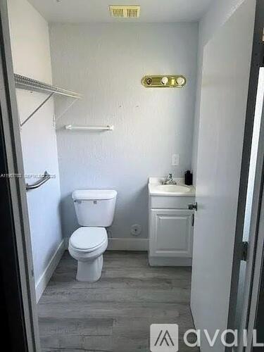 A bathroom with a toilet, sink, and a mirror.