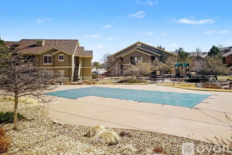 A swimming pool surrounded by houses and trees.