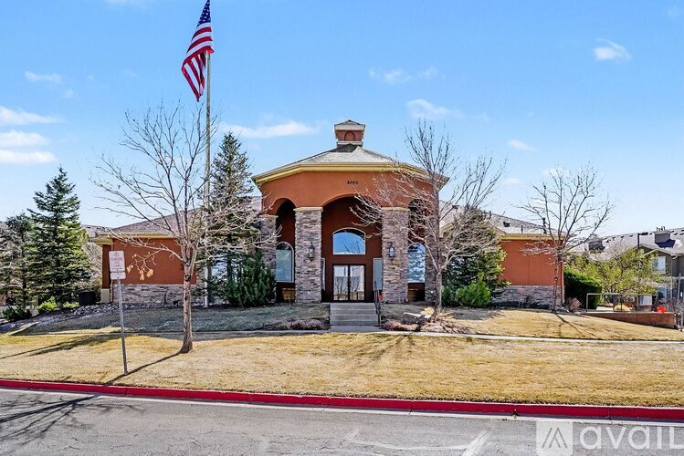 A building with a flag on top and a sign that says "available" in front of it.