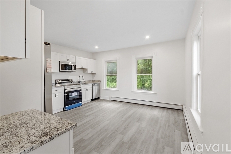 A kitchen with white cabinets and a granite countertop.