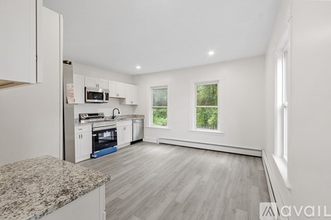 A kitchen with white cabinets and a granite countertop.