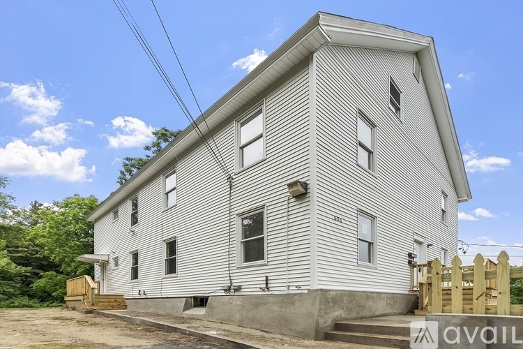 A house with a white exterior and a brown fence is for sale.