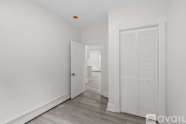 A room with a white door and a white wall.