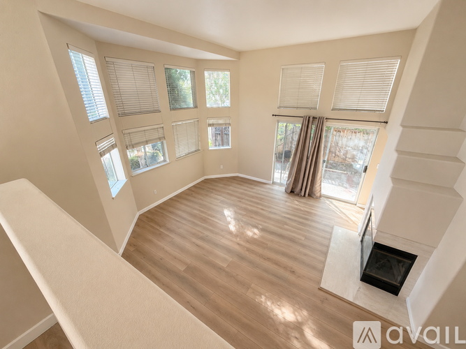 A living room with a fireplace and a large window.