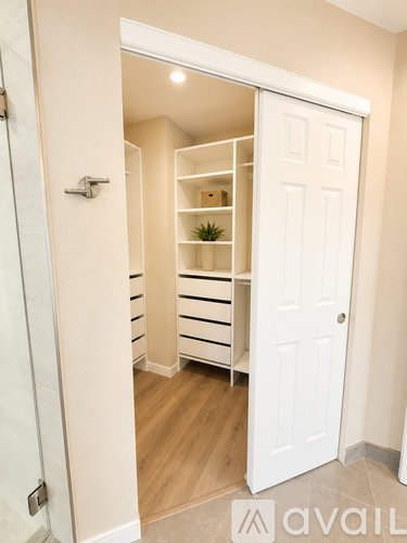 A white door opens to a small, organized storage space.