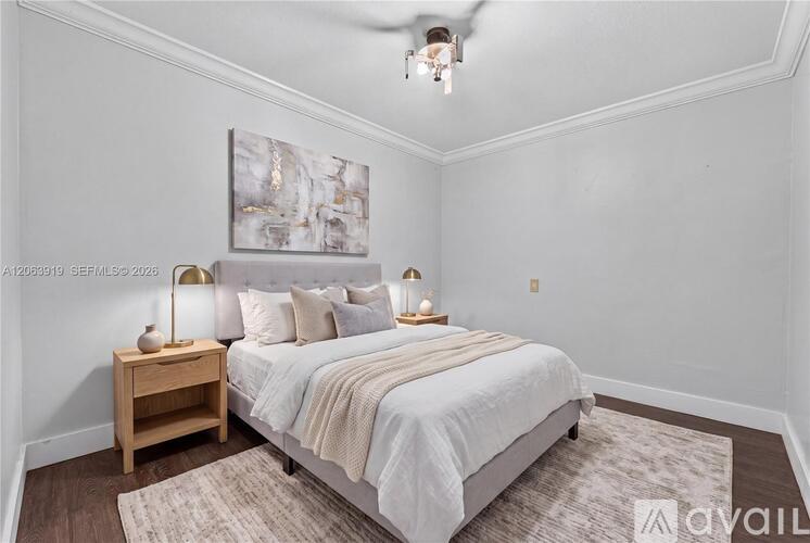A bedroom with a large bed and a painting on the wall.