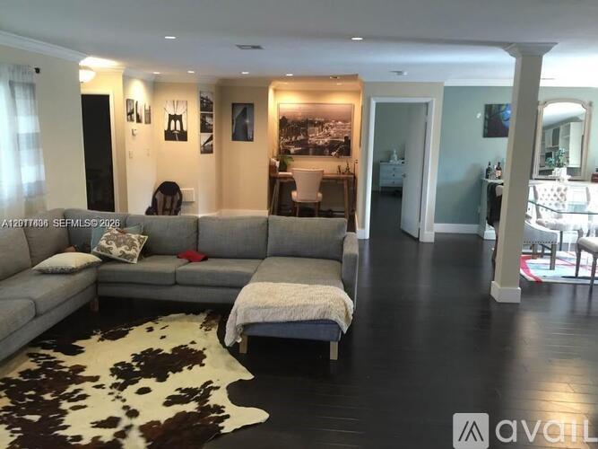 A living room with a grey couch and a cowhide rug.