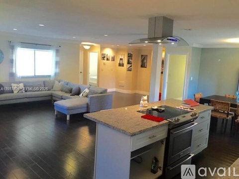 A modern kitchen with a large island and stove top oven.
