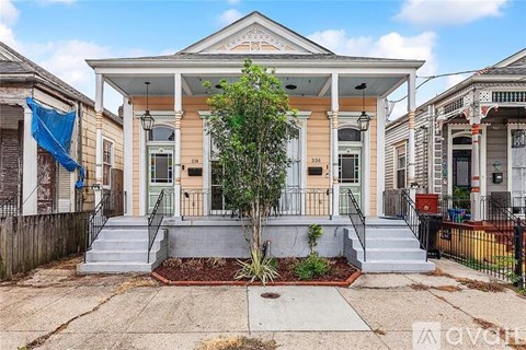 A house with a front porch and a tree in front.