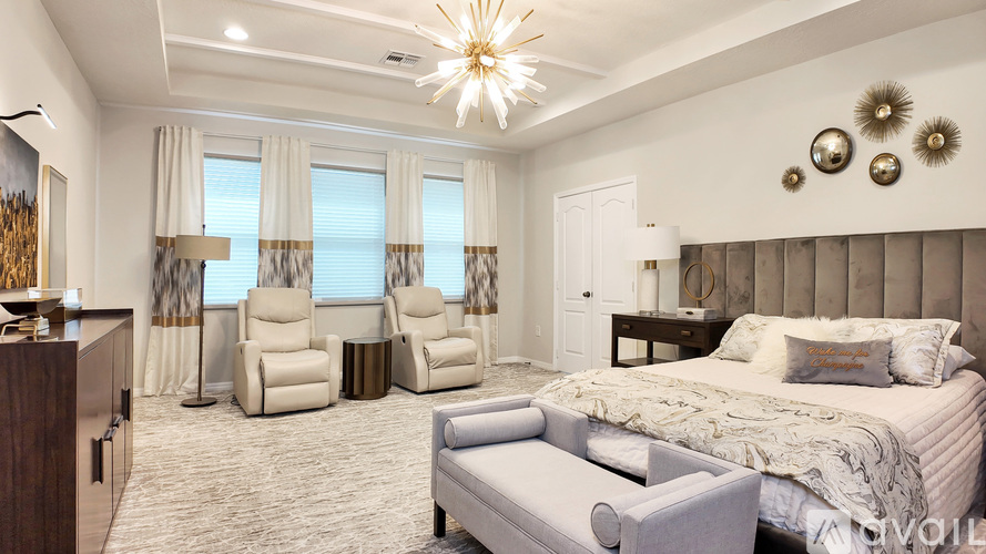 A bedroom with a large bed, a chair, and a couch.