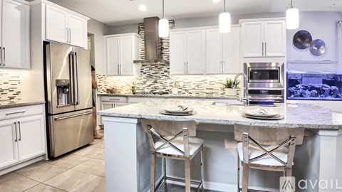 A kitchen with a marble countertop and stainless steel appliances.